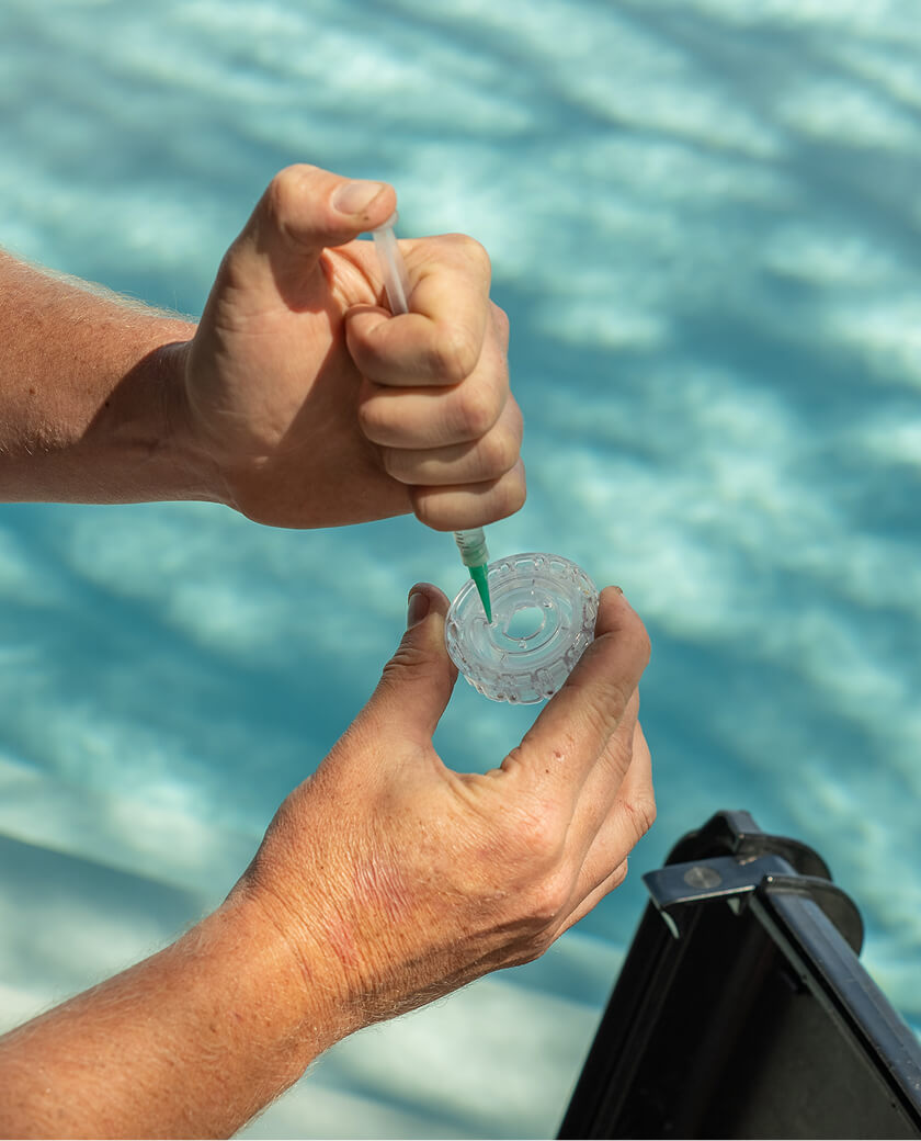 Close-up of a technician adding a reagent to a pool water test vial